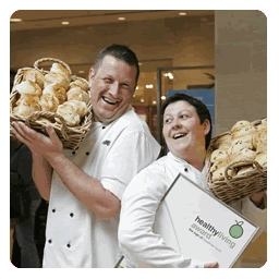  photograph of caterers holding bread rolls